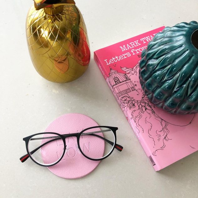 Photo graph of eyeglasses and a book.
