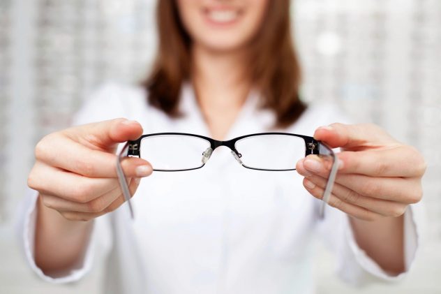 Woman holding eyeglasses with her two hands